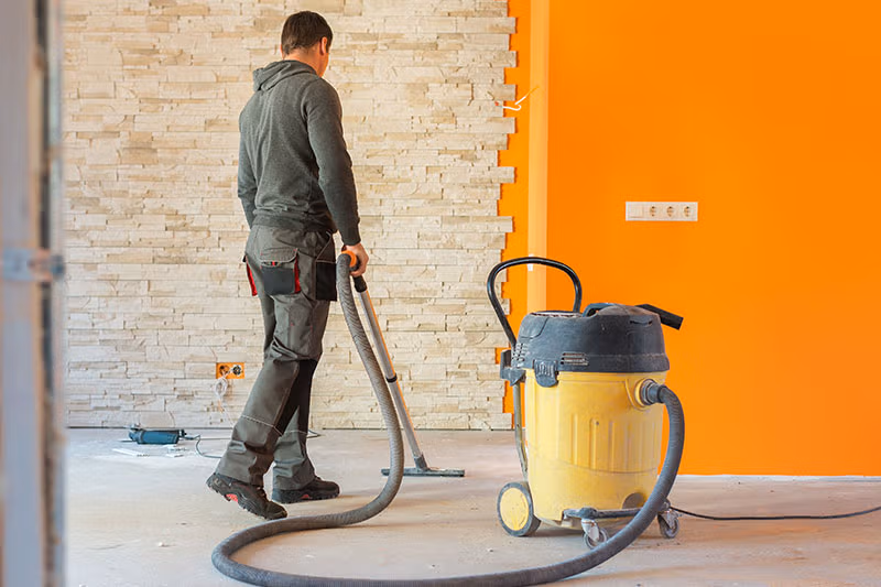 technicien avec aspirateur pour sol après travaux